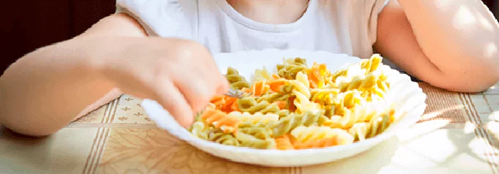 Niño comiendo un plato de pasta