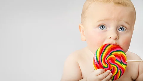 Bebé comiendo un dulce con azúcar