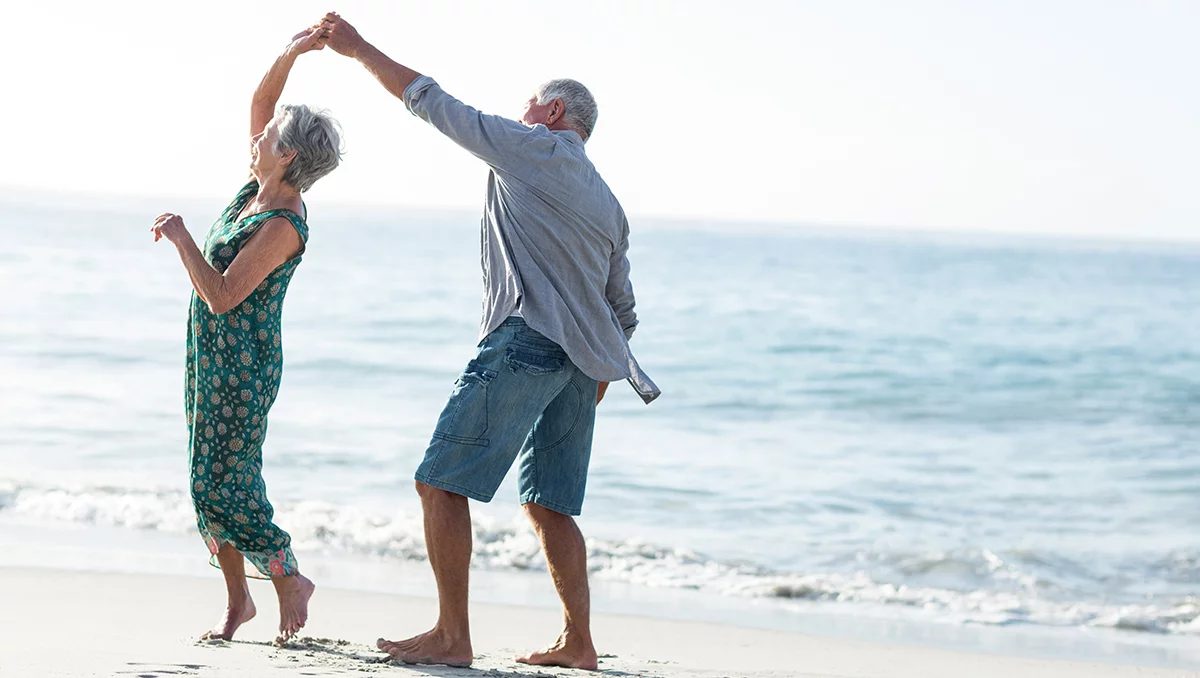 Pareja mayor bailando en la playa