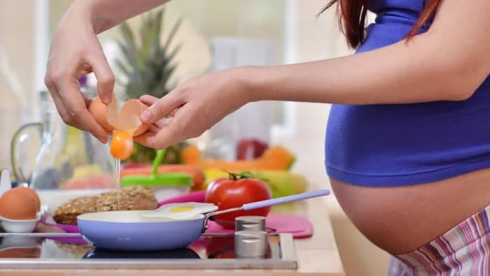 mujer haciendo huevo frito en el embarazo