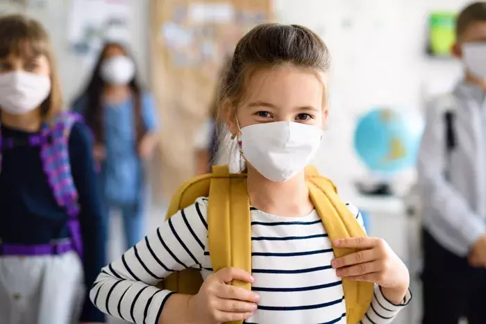 Niña con mascarilla en el colegio