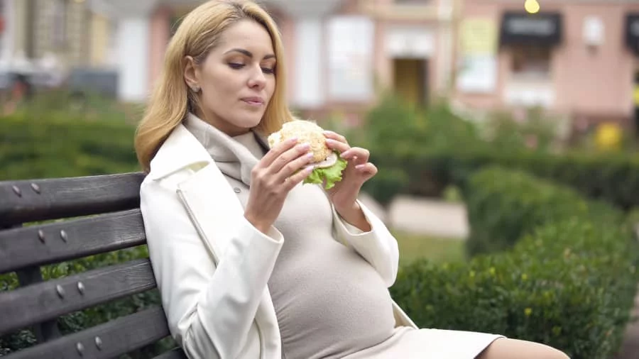 mujer comiendo sándwich de jamón cocido en el embarazo